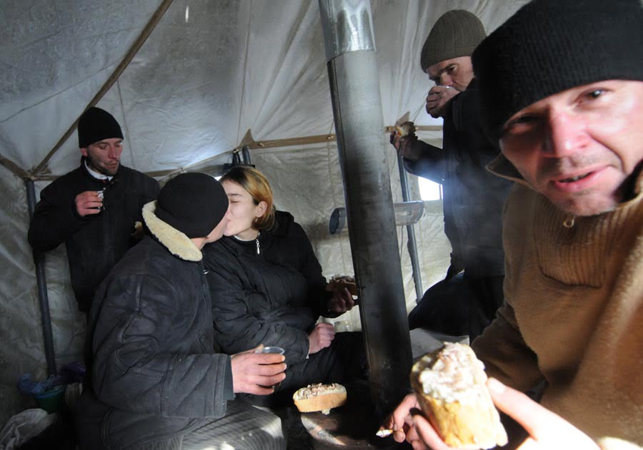 Gente sin hogar disfruta de una comida caliente en un refugio tienda en Lviv Ucrania